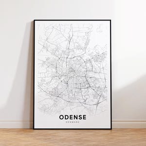 May include: A black and white line art map of Odense, Denmark. The map shows the city's streets and landmarks.