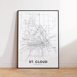 May include: A framed monochrome map print of St. Cloud, Minnesota. The detailed map shows the city's layout, streets, and waterways. The text "ST. CLOUD MINNESOTA" is printed at the bottom of the map in a clean, modern font.