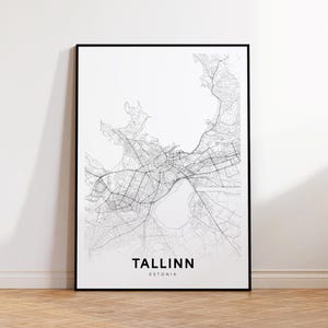 Puede incluir: Impresión de mapa de líneas en blanco y negro de Tallin, Estonia. La impresión está enmarcada en un marco negro y está colgada en una pared blanca.