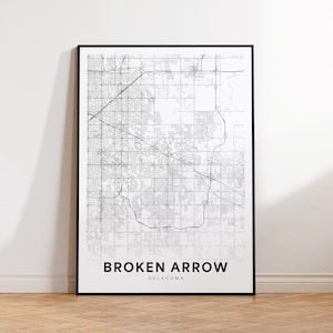 Puede incluir: Una impresión enmarcada en blanco y negro de un mapa de Broken Arrow, Oklahoma. El mapa presenta una cuadrícula detallada de calles y está etiquetado con el nombre de la ciudad en letras mayúsculas en negrita. La impresión se muestra sobre un suelo de madera.