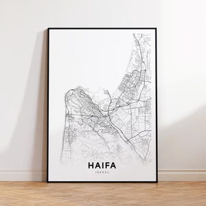 Puede incluir: Un mapa en blanco y negro enmarcado de Haifa, Israel. El mapa detalla las carreteras y la topografía de la ciudad. El nombre de la ciudad y el país están impresos en una fuente minimalista en la parte inferior. El mapa se muestra en un marco negro.