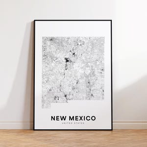 May include: A framed black and white map print of New Mexico, United States. The map shows the state's roads and cities in a detailed, grayscale design. The text "NEW MEXICO UNITED STATES" is printed in a clean, sans-serif font at the bottom.