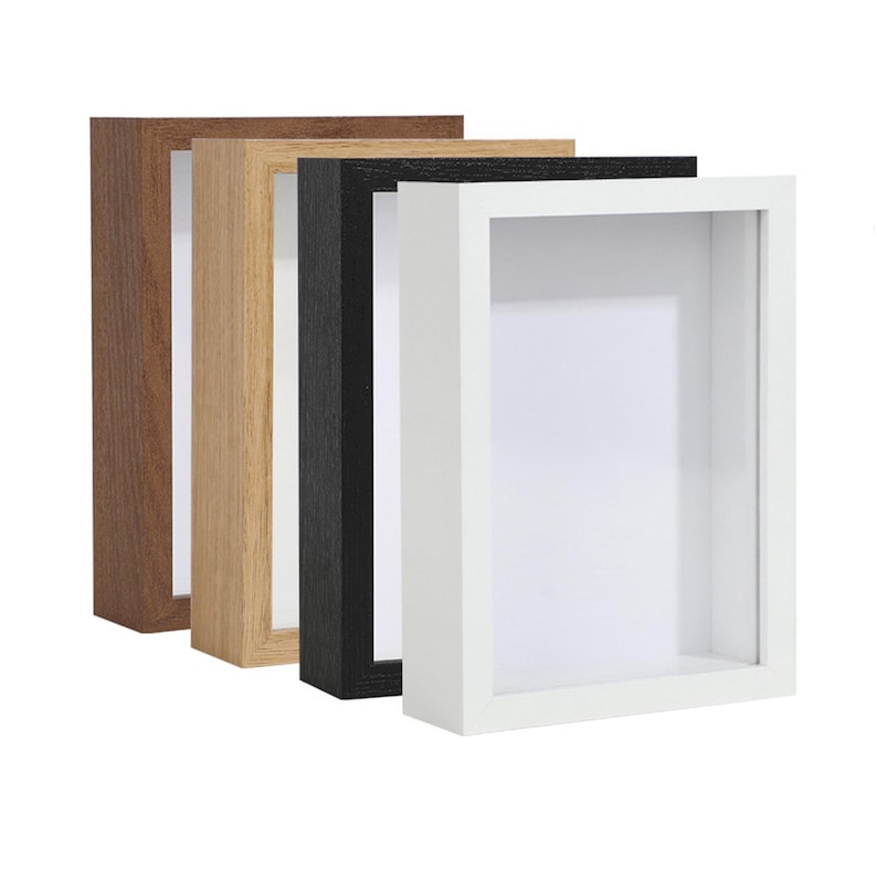 May include: Four shadow boxes in different colors: brown, light brown, black, and white. The shadow boxes are all the same size and have a simple, modern design.