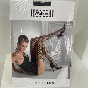 May include: A white package with black text that reads "SMALL" and "[Wolford]" on the top. The package shows a woman wearing black and white patterned tights with the text "FUJI POETRY TIGHTS" at the bottom.