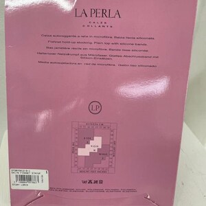May include: Pink and white packaging for La Perla tights. The packaging features a size chart in centimeters and inches. The text on the packaging is in Italian, English, German, and Spanish. The packaging also includes a care label with washing instructions.
