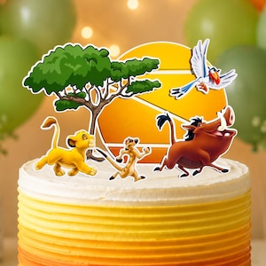 May include: A layered cake with a gradient of green, orange, and yellow frosting. The cake is decorated with cartoon character cutouts from The Lion King, including Simba, Timon, Pumbaa, and Zazu. The cake sits on a white cake stand, with balloons in the background.
