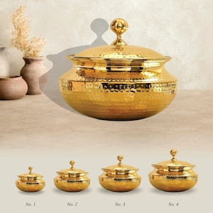 Puede incluir: Colección de cuatro tarros decorativos dorados con tapa y textura martillada. Los tarros varían en tamaño, con un tarro grande en la parte superior y tres tarros más pequeños debajo, cada uno numerado. Los tarros tienen un pomo decorativo en la tapa.