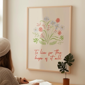 以下が含まれることがあります： 赤、青、緑の色合いの花のイラストが描かれた額入りのアートプリント。アートワークには、赤い筆記体で「To live for the hope of it all」というテキストが含まれています。明るい色の壁に飾られています。