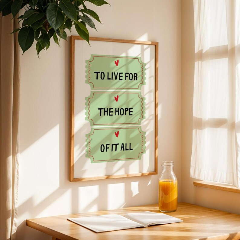 K&ouml;nnte beinhalten: Ein gerahmter Druck mit gr&uuml;nem Hintergrund und drei ticketf&ouml;rmigen Designs. Jedes Ticket hat ein rotes Herz und einen Text, der "To Live For", "The Hope" und "Of It All" lautet.