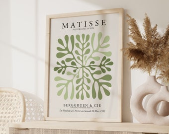 May include: A framed print of a green abstract art piece by Matisse. The print is titled "Papiers Decoupes" and includes the text "Berggruen & Cie" and "Du vendredi 27. Fevrier au samedi 28. Mars 1953".