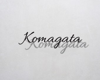 May include: The word "Komagata" written in cursive script with a shadow effect.