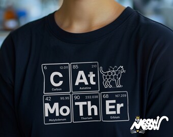 May include: A black t-shirt with a white graphic of the periodic table elements spelling out "CAT MOTHER" with a cat illustration in the "At" element box. The graphic also includes the atomic numbers and weights for each element.