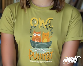 May include: A green t-shirt with a graphic design of an owl and a cat in a boat. The text on the shirt reads "The Owl and the Pussycat, The Pea-Green Boat Adventures".