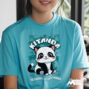 May include: A turquoise blue t-shirt with a cartoon panda wearing a black and white fur coat. The panda is sitting on a green bamboo branch with the text "Kitanda The Fusion of Kittens & Pandas" printed below.