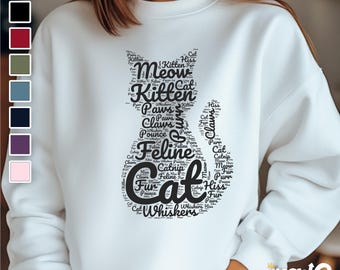 May include: White sweatshirt with a black cat silhouette made of words related to cats, such as "meow", "kitten", "paws", "claws", "feline", and "whiskers".