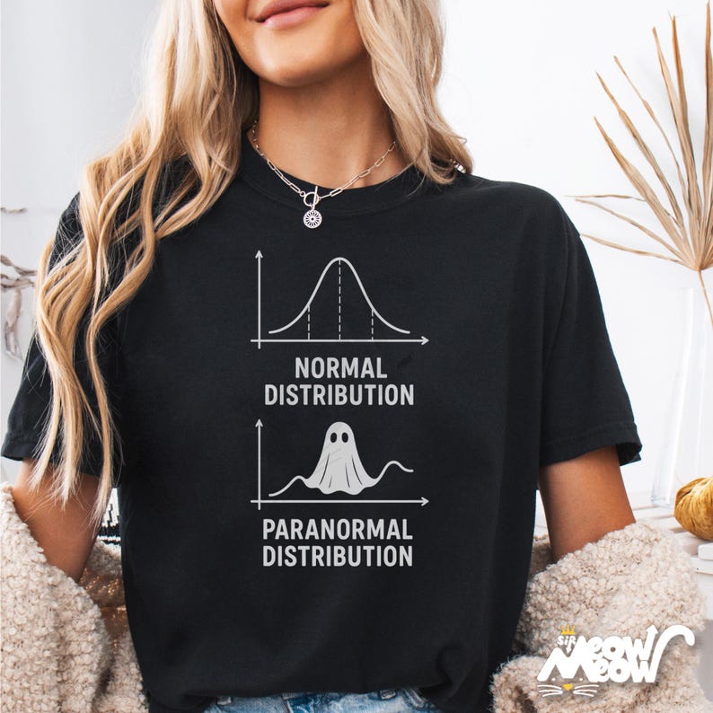 Op de afbeelding: Zwart T-shirt met een humoristische afbeelding die "Normale verdeling" vergelijkt met "Paranormale verdeling" met een spookillustratie. Het shirt heeft witte tekst en afbeeldingen. Een leuk, griezelig ontwerp voor Halloween of dagelijks gebruik.