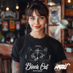 K&ouml;nnte beinhalten: Eine Frau tr&auml;gt ein schwarzes T-Shirt mit einer schwarzen Katzenillustration und dem Text "Black Cat Tattoo Parlor". Das Design enth&auml;lt die W&ouml;rter "Innovative", "Unique" und "Timeless".
