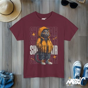 Humanized British Shorthair Cat standing up wearing a yellow hoodie and white and gray sneakers. Behind the cat is a stack of the word "Shorthair". The design appears on a woman wearing a maroon tee.