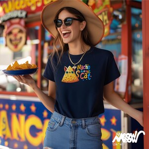 May include: A navy blue t-shirt with a cartoon cat shaped like a nacho chip. The text "Nacho Average S.Cat." is printed on the shirt.