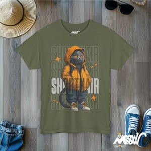 Humanized British Shorthair Cat standing up wearing a yellow hoodie and white and gray sneakers. Behind the cat is a stack of the word "Shorthair". The design appears on a woman wearing a army green tee.