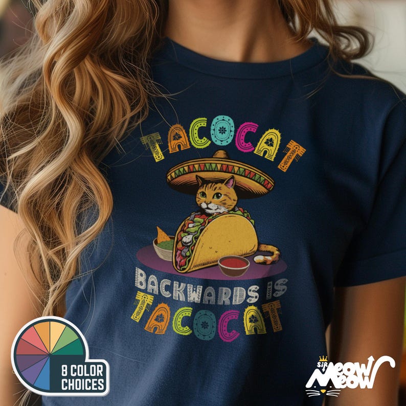 May include: A navy blue t-shirt with a colorful graphic of a cat wearing a sombrero and holding a taco. The text "Tacocat backwards is Tacocat" is printed below the graphic.