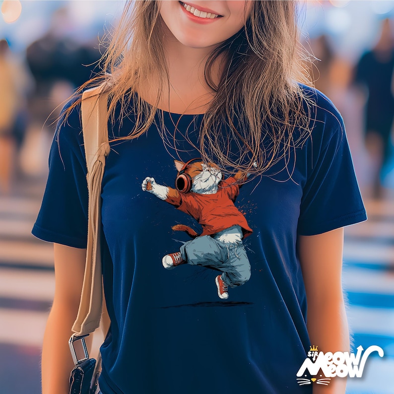 May include: Navy blue t-shirt featuring a dancing cat wearing headphones, a red shirt, blue jeans, and red sneakers. The cat illustration has its arms outstretched. The shirt has the text "Sip Meow Meow" at the bottom.