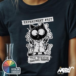 May include: A black and white illustration of a cat wearing a lab coat and holding two beakers. The cat is labeled "Experiment #427" and "The Evasive Hairball Remedy".