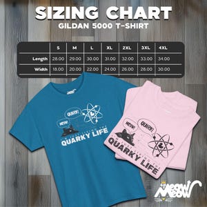 May include: A teal blue and pink t-shirt with a black cat graphic and the text "I'm just living the quirky life" and "Meow!" and "Quark!" printed on the front. The t-shirt is available in sizes S-4XL. A sizing chart is included in the image.