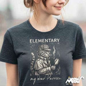 May include: Dark gray t-shirt featuring a cartoon cat dressed as Sherlock Holmes, complete with a hat, coat, pipe, and magnifying glass. The text "ELEMENTARY my dear Purrson" is printed above and below the illustration. The Sir Meow logo is in the bottom right.
