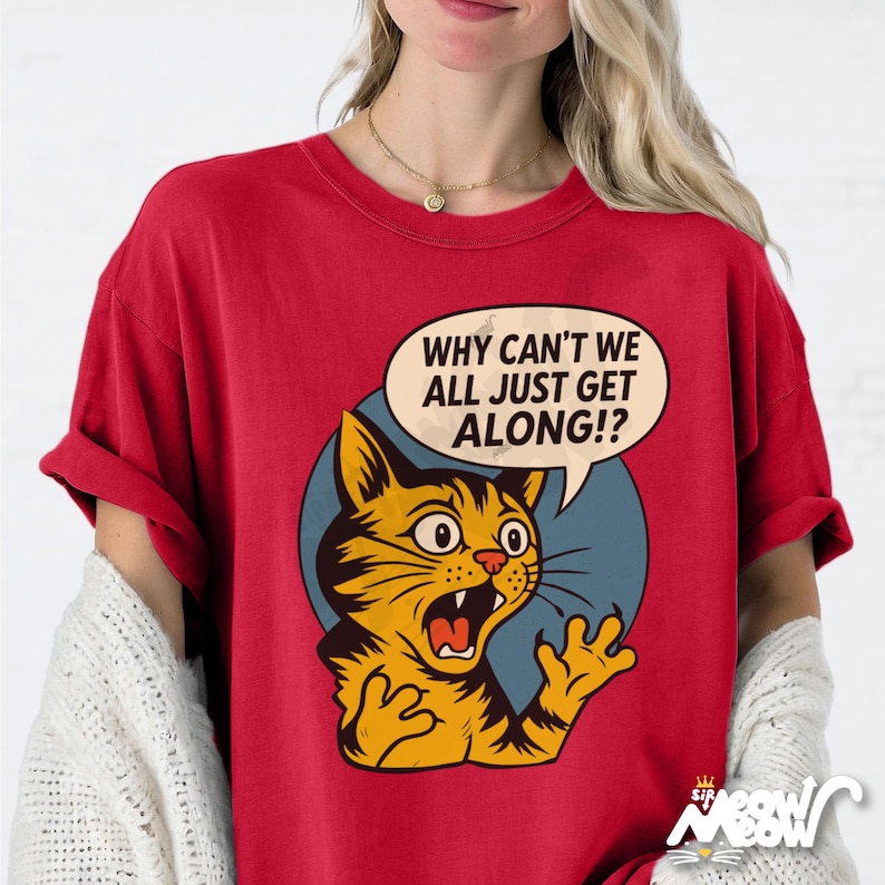 May include: Red t-shirt featuring a distressed graphic of a surprised orange cat with the text "WHY CAN'T WE ALL JUST GET ALONG!?" in a speech bubble. The cat is set against a blue circle.