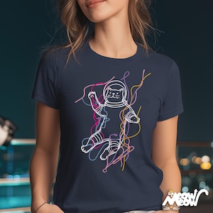 May include: Navy blue t-shirt featuring a white outline illustration of a cat in an astronaut suit, with colorful lines. The shirt has the text "Sir Meow Meow" at the bottom right.