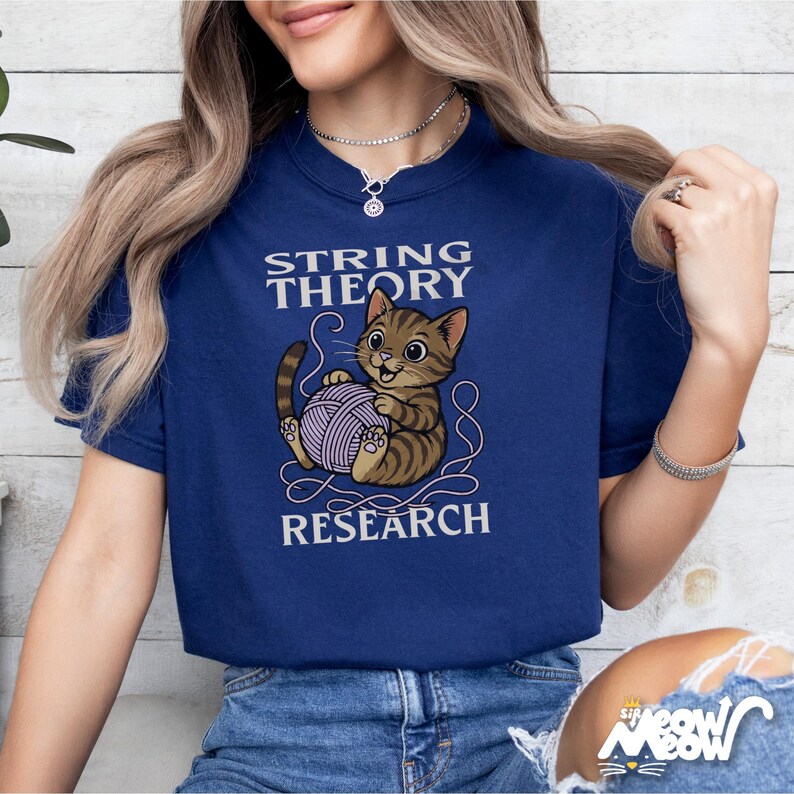 May include: A navy blue t-shirt with a cartoon cat holding a ball of yarn. The text "String Theory Research" is printed on the shirt.