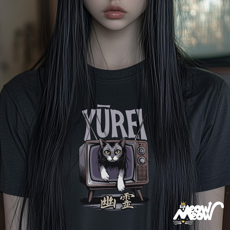 Op de afbeelding: Zwart T-shirt met een afbeelding van een kat in een vintage televisie. De tekst "YUREK" staat boven de televisie en de tekst "幽霊" staat onder de televisie.