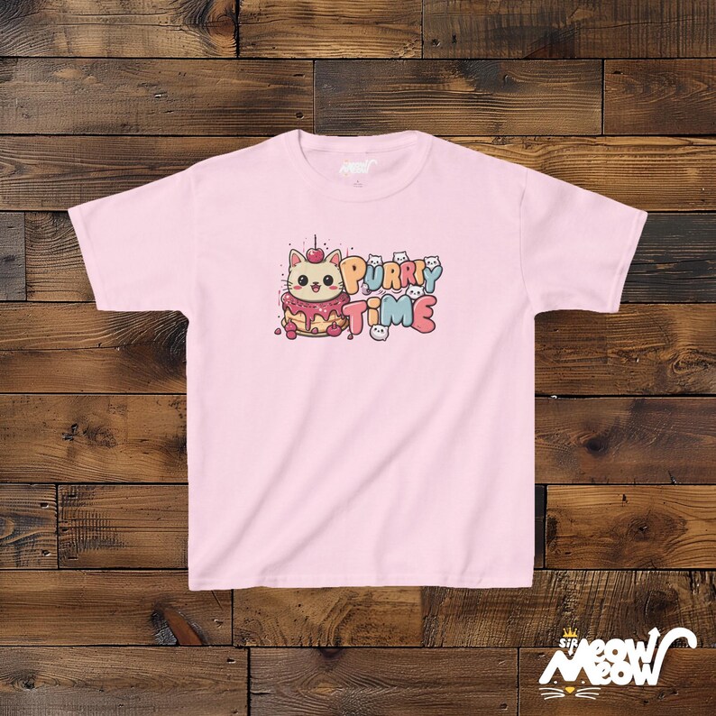 K&ouml;nnte beinhalten: Rosa T-Shirt mit einer Comic-Katze, die einen rosa-wei&szlig;en Hut tr&auml;gt und ein St&uuml;ck Kuchen h&auml;lt. Der Text "Purr-y Time" ist auf dem Shirt aufgedruckt.