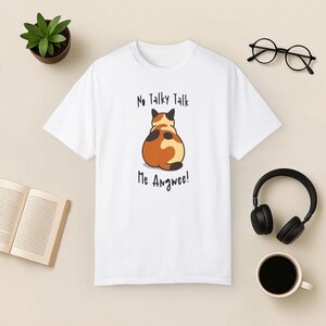 K&ouml;nnte beinhalten: Wei&szlig;es T-Shirt mit einer Cartoon-Katze auf der R&uuml;ckseite. Die Katze ist orange, schwarz und wei&szlig; und hat den Text "No Talky Talk Me Angwee!" darunter gedruckt.