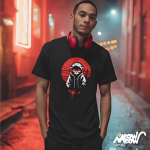 May include: Black t-shirt featuring a white graphic of a cat wearing sunglasses and a hoodie, set against a red circle and lines. The shirt has the text "sip meow meow" in white. The person in the image is wearing red headphones.