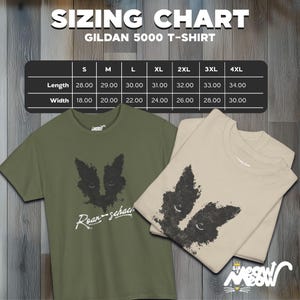 May include: A sizing chart for Gildan 5000 T-shirts, showing measurements in inches for length and width, for sizes S through 4XL. The chart is displayed on a wooden background. Two T-shirts are shown below the chart, one in olive green and one in beige, both featuring a black and white graphic of a cat's face.