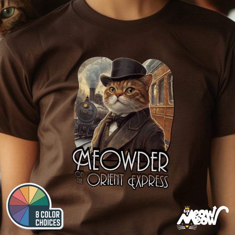 May include: A brown t-shirt with a cat illustration wearing a suit and top hat, with the text "MEOWDER ON THE ORIENT EXPRESS". The design includes a train and a colour palette graphic.