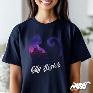 Pode incluir: Uma camiseta azul marinho com a silhueta de um gato com um horizonte da cidade dentro do corpo do gato. O texto "City Nights" est&aacute; impresso em branco abaixo da silhueta do gato.