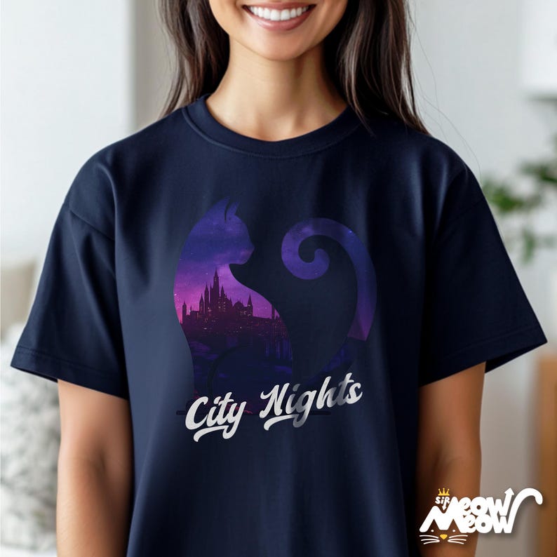 Pode incluir: Uma camiseta azul marinho com a silhueta de um gato com um horizonte da cidade dentro do corpo do gato. O texto "City Nights" est&aacute; impresso em branco abaixo da silhueta do gato.