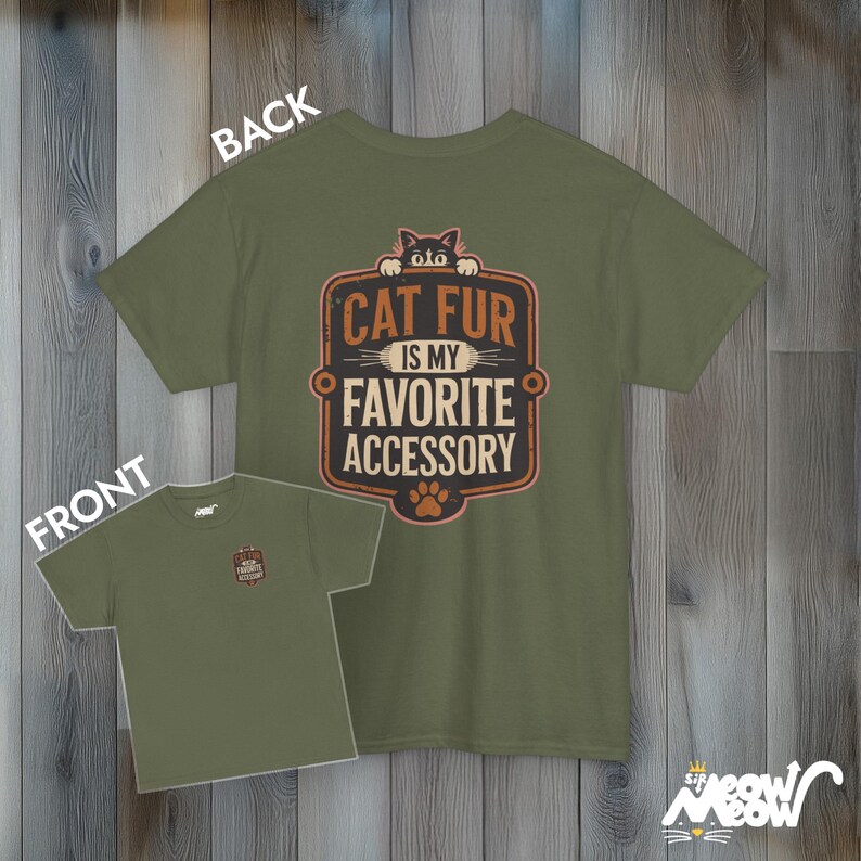 May include: A green t-shirt with a cat peeking out from the top and the text "Cat fur is my favorite accessory". The back of the shirt is plain green.