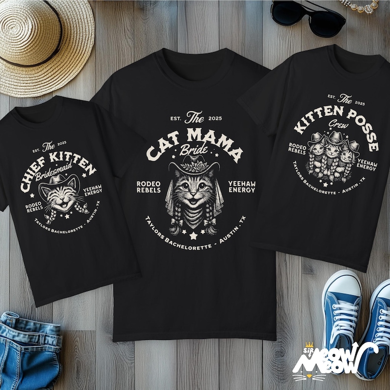 May include: Three black t-shirts with cat-themed graphics. One says "Chief Kitten Bridesmaid," another "Cat Mama Bride," and the third "Kitten Posse Crew." All shirts feature a cat wearing a cowboy hat and the text "Rodeo Rebels, Yeehaw Energy, Taylors Bachelorette, Austin, TX."