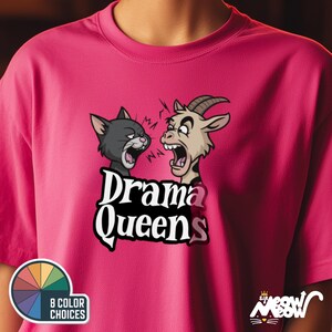K&ouml;nnte beinhalten: Pinkes T-Shirt mit einem Cartoon-Bild eines Katers und einer Ziege mit dem Text "Drama Queens".