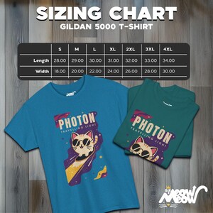 May include: A sizing chart for Gildan 5000 T-shirts, showing measurements in inches for length and width, for sizes S through 4XL. The chart is displayed on a woodgrain background. Two t-shirts are shown below the chart, one blue and one teal, both featuring a cartoon cat wearing sunglasses and the text "PHOTON TRAVELLING LIGHT".