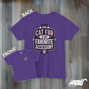 May include: Purple t-shirt with a pink and black graphic that says "Cat fur is my favorite accessory".