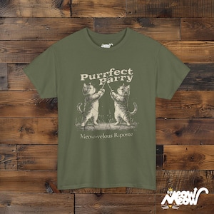 May include: A green t-shirt with a graphic of two cats fencing. The text on the shirt reads "Purrfect Parry Meow-velous Riposte".
