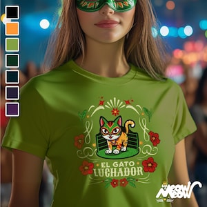 May include: Green t-shirt with a cartoon cat wearing a wrestling mask. The cat is in a wrestling ring with the text "El Gato Luchador" below it. The design is surrounded by flowers and stars.