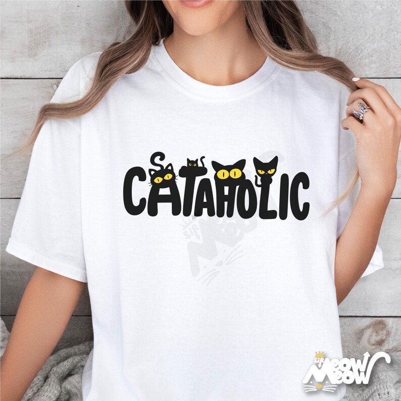 Pu&ograve; includere: T-shirt bianca con la scritta "CATAHOLIC" in nero, con sagome di gatti con occhi gialli. La maglietta ha girocollo e maniche corte. Il disegno &egrave; centrato sul davanti della maglietta.
