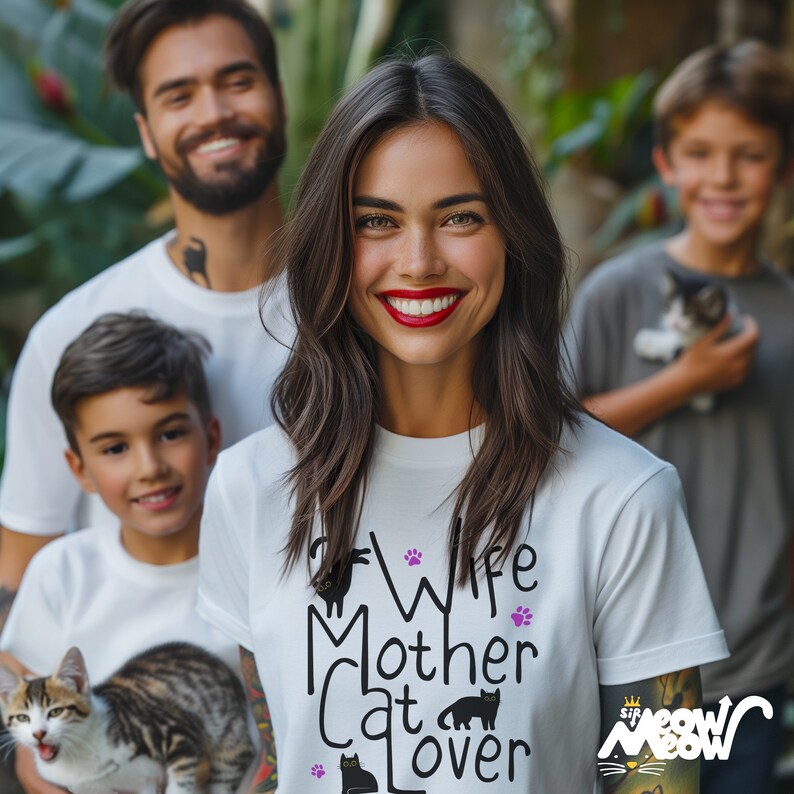 Puede incluir: Una camiseta blanca con el texto "Wife Mother Cat Lover" en letras negras con huellas de patas y siluetas de gatos negros. El texto "Sir Meow Meow" est&aacute; impreso en rosa en la manga.