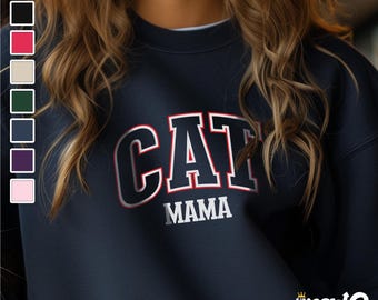 May include: A navy blue sweatshirt with the text "CAT MAMA" in white with red outlining. The sweatshirt has a crew neck and long sleeves.